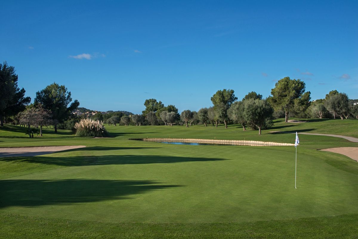 Sunlit green with a flagstick and open sky at Golf Santa Ponsa I, Mallorca