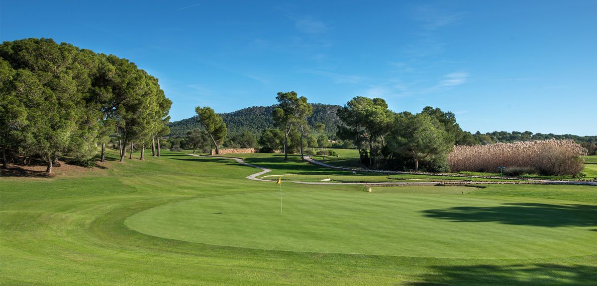 Fairway and green with tree-covered hills at Golf Santa Ponsa I, Mallorca