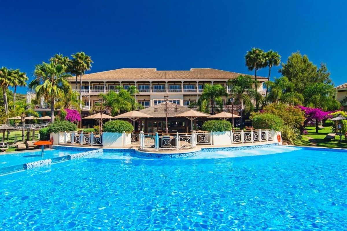 Pool and palm trees in front of the Lindner Hotel Mallorca Portals Nous