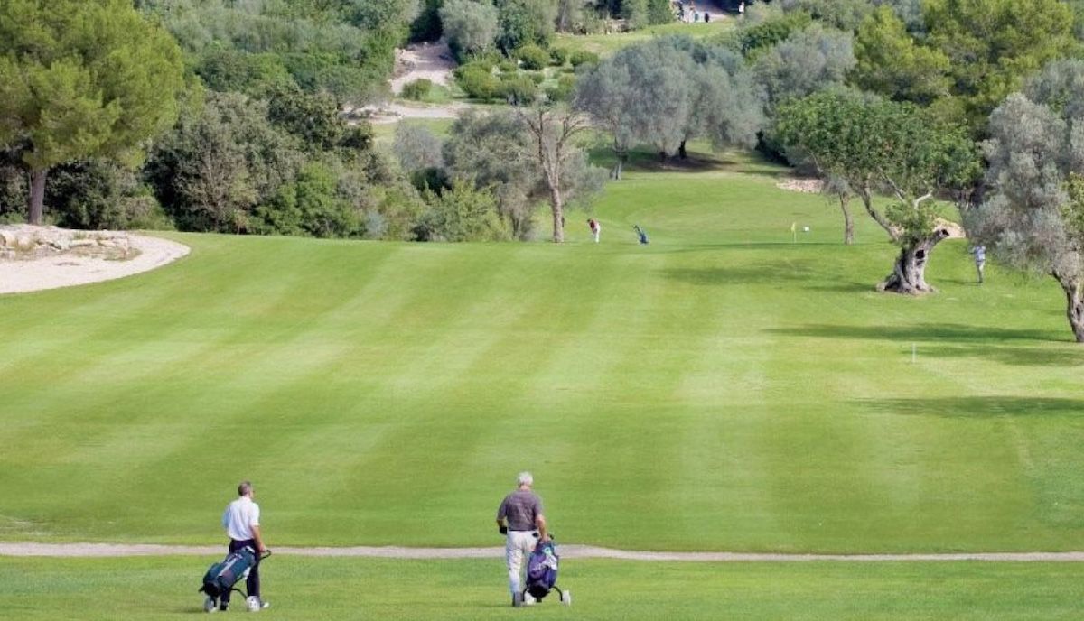 Two golfers with trolleys on the fairway at Golf Pollensa, Mallorca