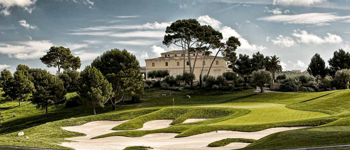 Clubhaus hinter Sandbunkern und Kiefern – Son Gual Golf, Mallorca