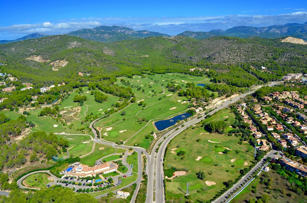 Luftaufnahme von Platz und Clubhaus unterhalb der Berge – Arabella Golf Son Quint, Mallorca