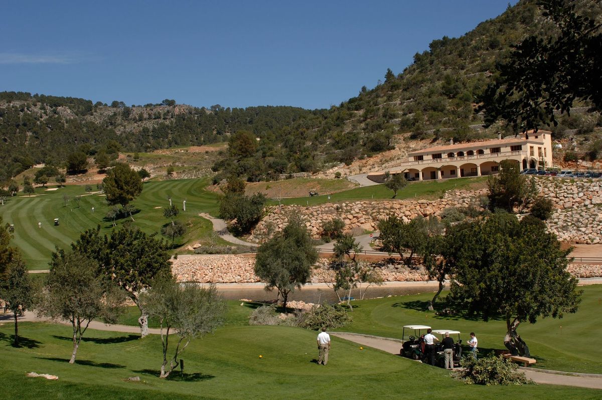 Golfeurs et voiturette sous le club-house en pierre – Son Termes Golf Club, Mallorca