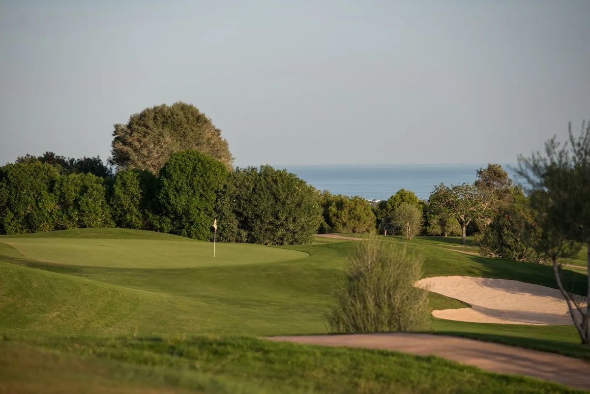 Calle y búnkeres con un atisbo del mar – Vall d'Or Golf, Mallorca