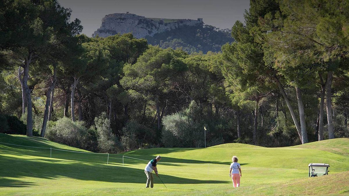 Dos golfistas en la calle al pie de las montañas – Vall d'Or Golf, Mallorca