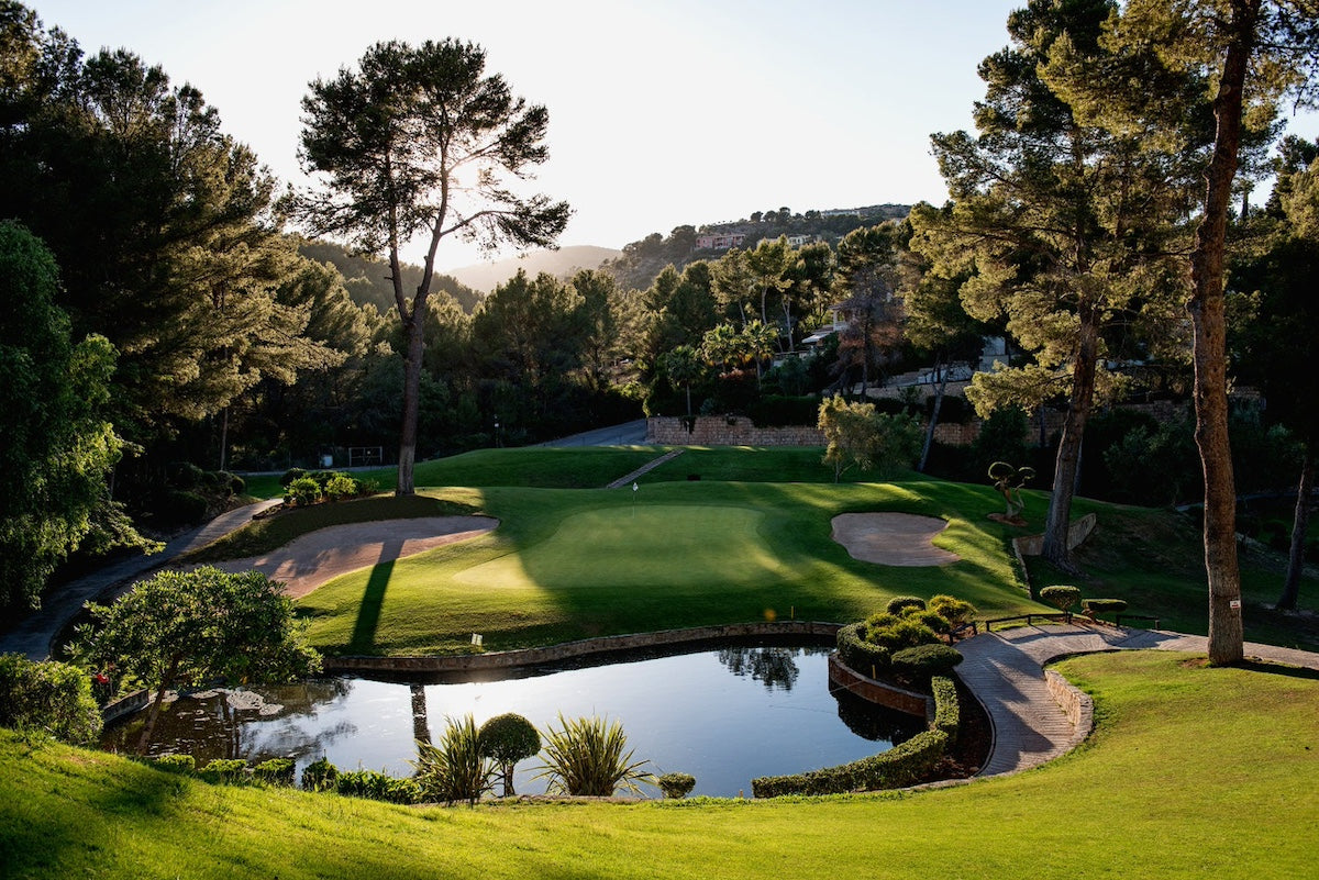 Grün mit kleinem Teich, gerahmt von Kiefern – Arabella Golf Son Vida, Mallorca